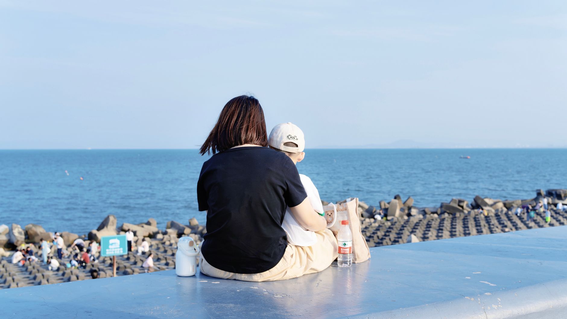 並んで座って話す親子の後ろ姿