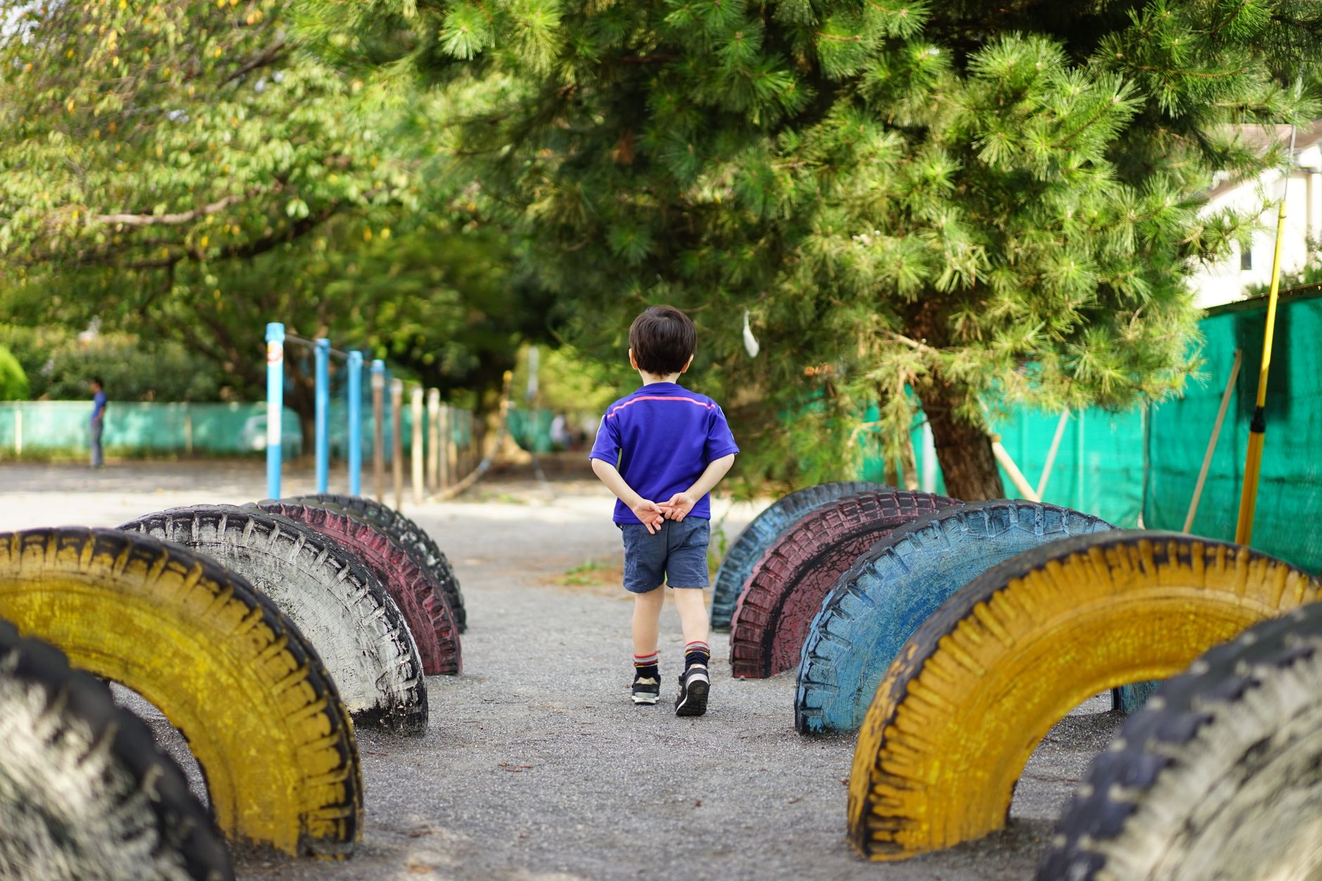 校庭でひとり立っている子どもの後ろ姿